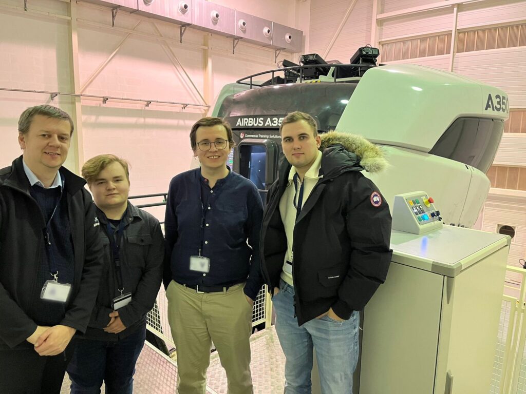iniBuilds' team members in front of a professional A350 simulator